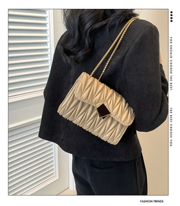 Détail du sac à bandoulière matelassé beige avec chaîne dorée et fermoir chic