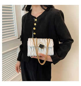 Détail du sac matelassé blanc avec chaîne dorée et fermoir métallique carré élégant