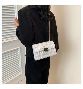 Détail de la sacoche matelassée blanche avec chaîne dorée et fermoir en losange