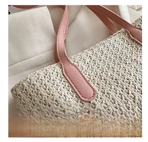 Gros plan sur le tissage en paille et la poignée en cuir rose aux coutures fines