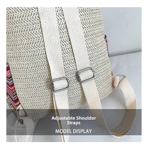 Detailed macro view of adjustable canvas shoulder straps and metallic buckles on straw backpack