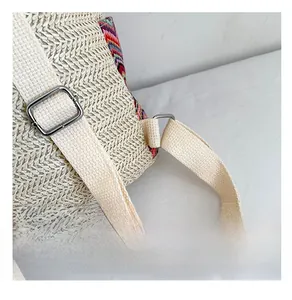 Close-up of woven straw texture with ethnic fabric patterns and silver metal buckles