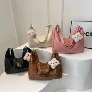 Minimalist large tote bags in four colors with star charms on white display stands