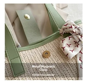 Detail of straw woven bag featuring green leather trim and a silk scarf on handle