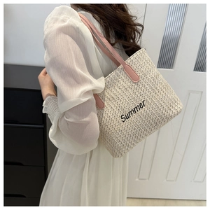 Détail de la broderie Summer sur un sac cabas tissé beige avec des anses roses chic