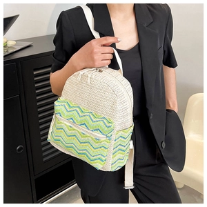 Close-up of colorful straw backpack with woven zigzag patterns and dual zipper pockets