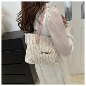 Detail of woven straw tote bag with pink straps and black Summer embroidery
