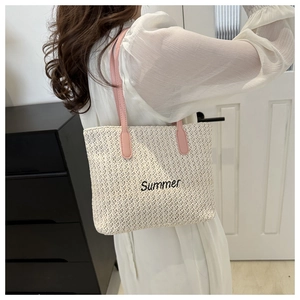 Détail du sac fourre-tout en paille tissée avec broderie Summer et bandoulières roses
