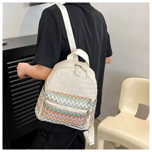 Close-up of ethnic woven backpack featuring colorful wave patterns and metal zippers