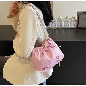 Détail du sac nuage froncé rose avec nœuds décoratifs et bandoulière en chaîne argentée