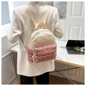Detailed back view of a woven straw backpack with colorful zigzag ethnic patterns