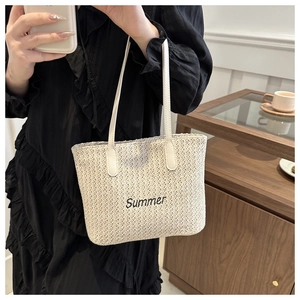 Détail du sac cabas en paille tissée avec broderie Summer et anses en cuir élégantes