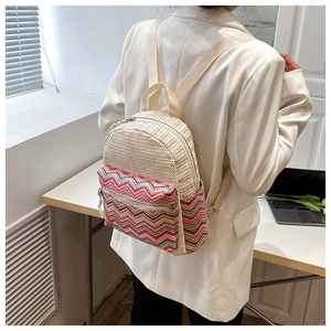 Detailed shot of bohemian straw patchwork backpack with colorful wave patterned textile