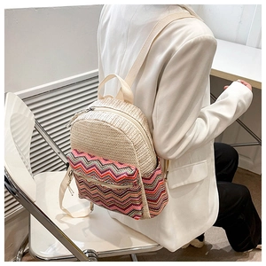 Detail view of bohemian chevron straw backpack worn by a model in a white blazer