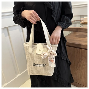 Detail of straw woven bag with Summer embroidery, white leather handle and floral silk scarf