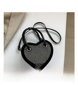 Dettaglio della borsa nera a cuore con borchie argentate e finitura lucida a specchio