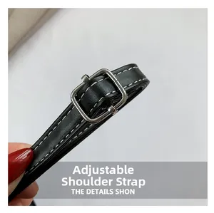 Dettaglio della tracolla regolabile in ecopelle nera con fibbia in argento e cuciture