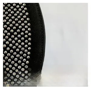 Dettaglio del tessuto nero opaco con decorazioni in strass argentati scintillanti