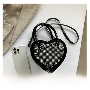 Dettaglio della mini borsa a cuore nera con borchie argento e doppi manici corti