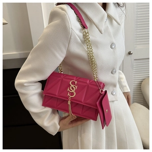 Détail du sac à bandoulière rose fuchsia avec matelassage géométrique et chaîne dorée