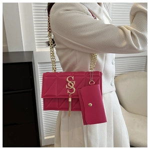 Vue détaillée du sac matelassé fuchsia avec chaîne dorée et pompon à logo