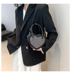 Elegante borsa nera a forma di cuore con strass argentati indossata dal modello