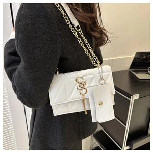 Détail du sac à bandoulière blanc matelassé avec logo doré et pochette amovible