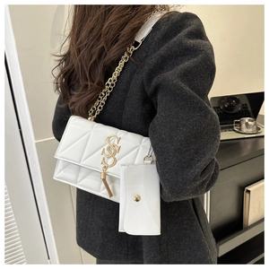 Détail du sac bandoulière blanc matelassé avec logo SSS doré et mini pochette amovible