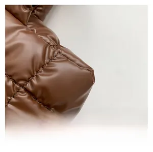 Macro detail of dark coffee quilted nylon fabric with diagonal rhombic stitching