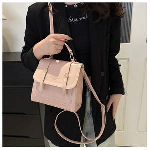 Detail der rosa Kunstledertasche mit vertikalen Riemen und goldener runder Schnalle