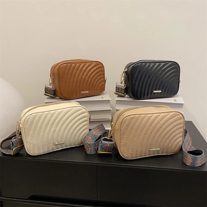 Quilted crossbody bags with wide patterned straps in brown, black, beige, and khaki colors
