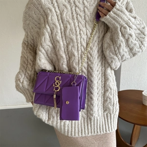 Sac bandoulière matelassé violet avec chaîne dorée porté par un mannequin