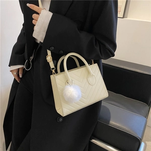 Borsa a tracolla chic bianco crema con trapuntatura a V, doppi manici e ciondolo fluffy