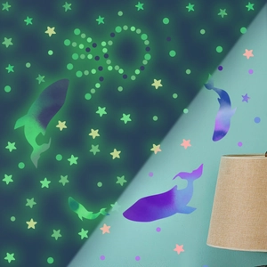 Luminous wall stickers with dolphins and stars glowing bright green in the dark for bedrooms
