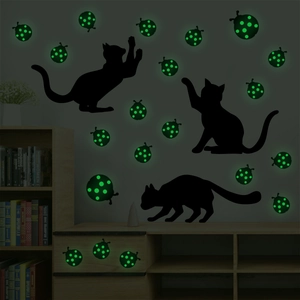Luminous cat and ladybug wall stickers showing green fluorescent effect in dark room