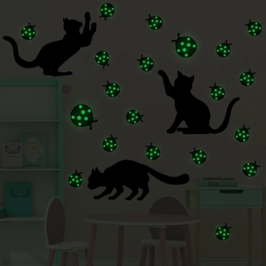 Luminous cat and ladybug wall decals set glowing in a dark cozy bedroom setting