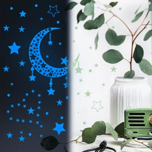 Detailansicht der leuchtenden blauen Stern- und Mond-Wandaufkleber im dunklen Zimmer