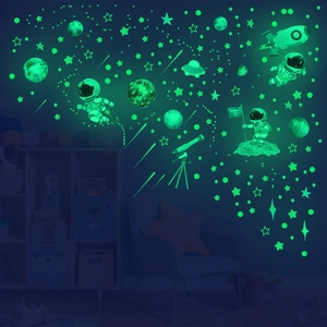 Luminous space wall stickers with astronauts, rockets and stars glowing in dark room