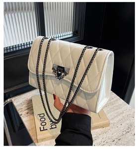 Close-up of white quilted leather bag with silver chain strap and metallic clasp