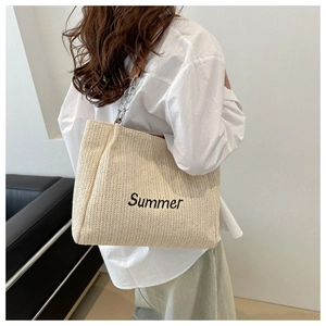 Detail of woven tote bag with Summer embroidery and metal chain leather shoulder strap
