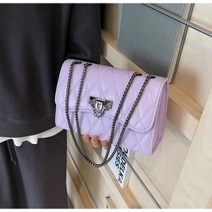 Detailed view of lavender quilted PU leather handbag with dark grey metal chain and lock