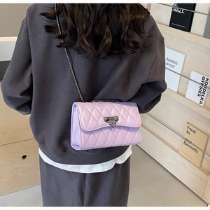Detail of lavender quilted chain bag featuring elegant diamond stitching and metal lock
