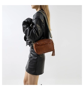 Brown faux leather crossbody bag with V-shaped stitching and colorful woven strap