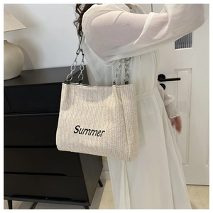 Detail of the Summer embroidered lettering on the large straw tote bag with chain strap