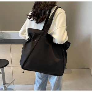 Close-up of waterproof black nylon tote bag with drawstring detail for daily commuting