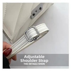 Détail de la bandoulière réglable avec boucle argentée sur un sac blanc matelassé