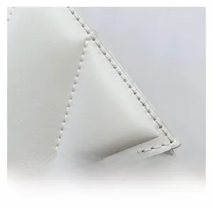 Vue rapprochée de la texture en cuir blanc matelassé géométrique avec coutures précises