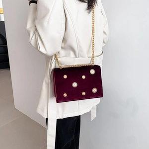 Fashionable burgundy velvet tote bag with gold star accents and chain strap