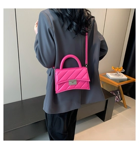 Détail du sac bandoulière matelassé rose rouge avec fond incurvé et boucle métallique