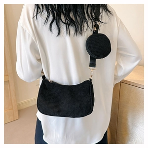 Détail du sac d'épaule en velours côtelé noir avec mini pochette ronde et zip doré brillant